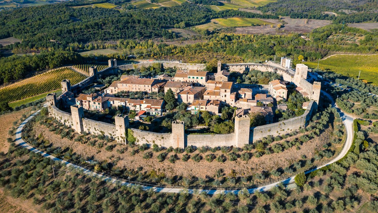 The walled hill town of Monteriggioni ringed by cypress and olive groves, Tuscany